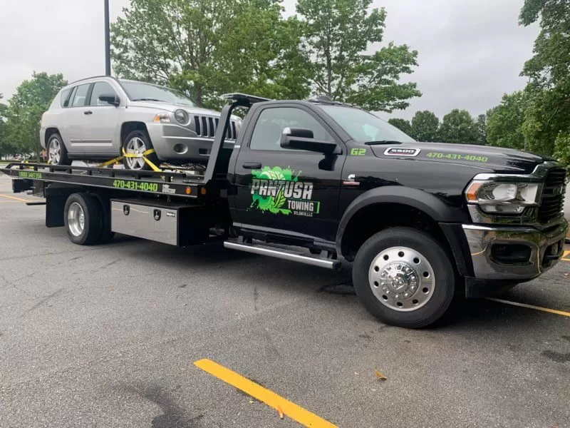 Black truck carrying a car on display